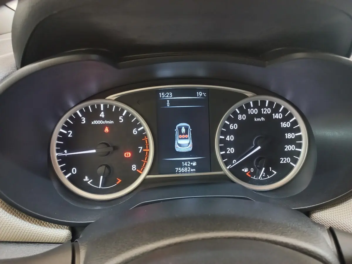 Vue rapprochée du tableau de bord de la Nissan Micra blanc, affichant compte-tours, vitesse et écran multifonctions.
