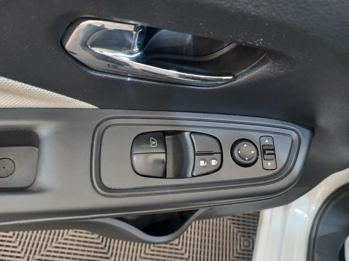 Gros plan sur la commande de lève-vitres et rétroviseurs côté conducteur de la Nissan Micra blanche 2018.