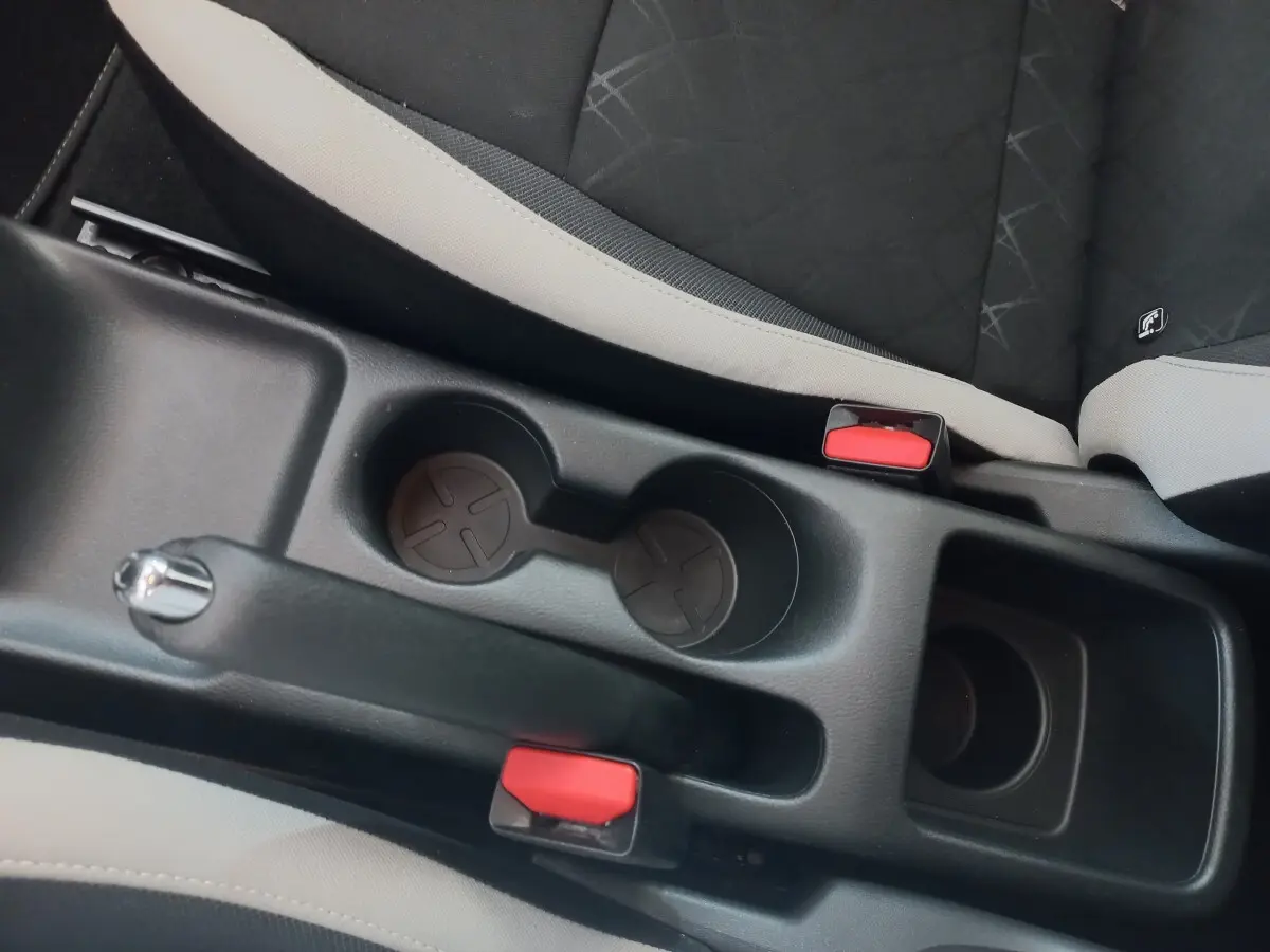 Vue rapprochée de la console centrale noire entre les sièges avant gris et noir de la Nissan Micra IG-T 90 Business Edition.