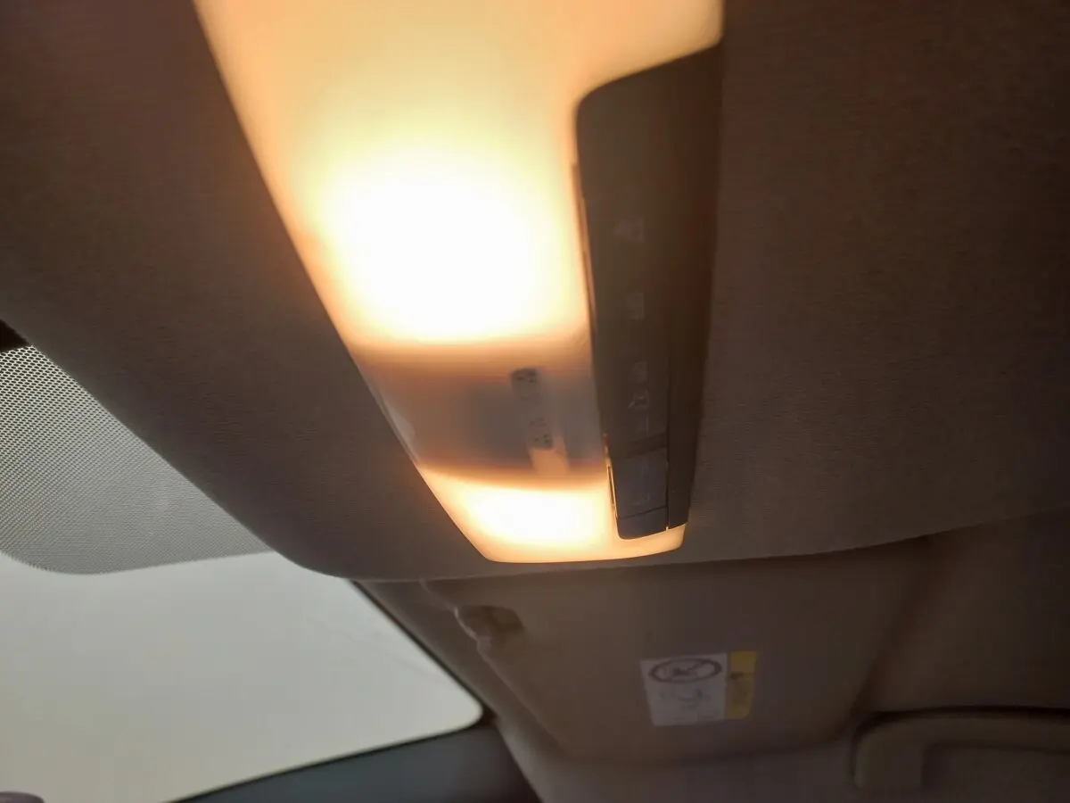 Plafonnier intérieur allumé vu de dessous dans une Nissan Micra blanche, version IG-T 90 Business Edition.