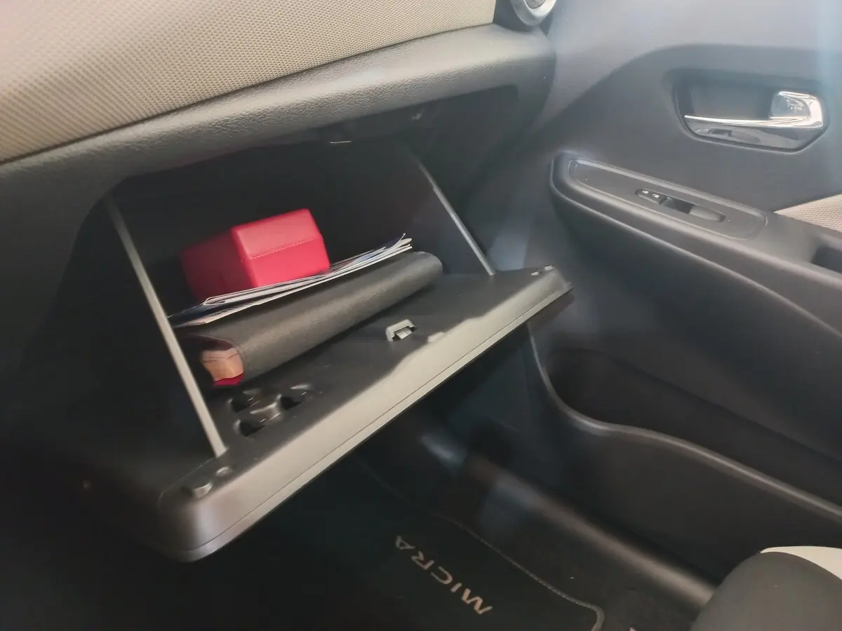 Intérieur de la Nissan Micra IG-T 90 Business Edition 2018, vue du côté passager avec boîte à gants ouverte contenant des documents.