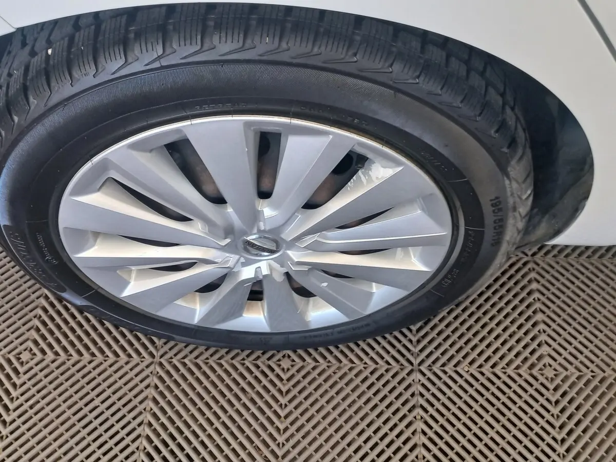 Gros plan sur la roue avant droite de la Nissan Micra blanche, jante en alliage au design moderne.