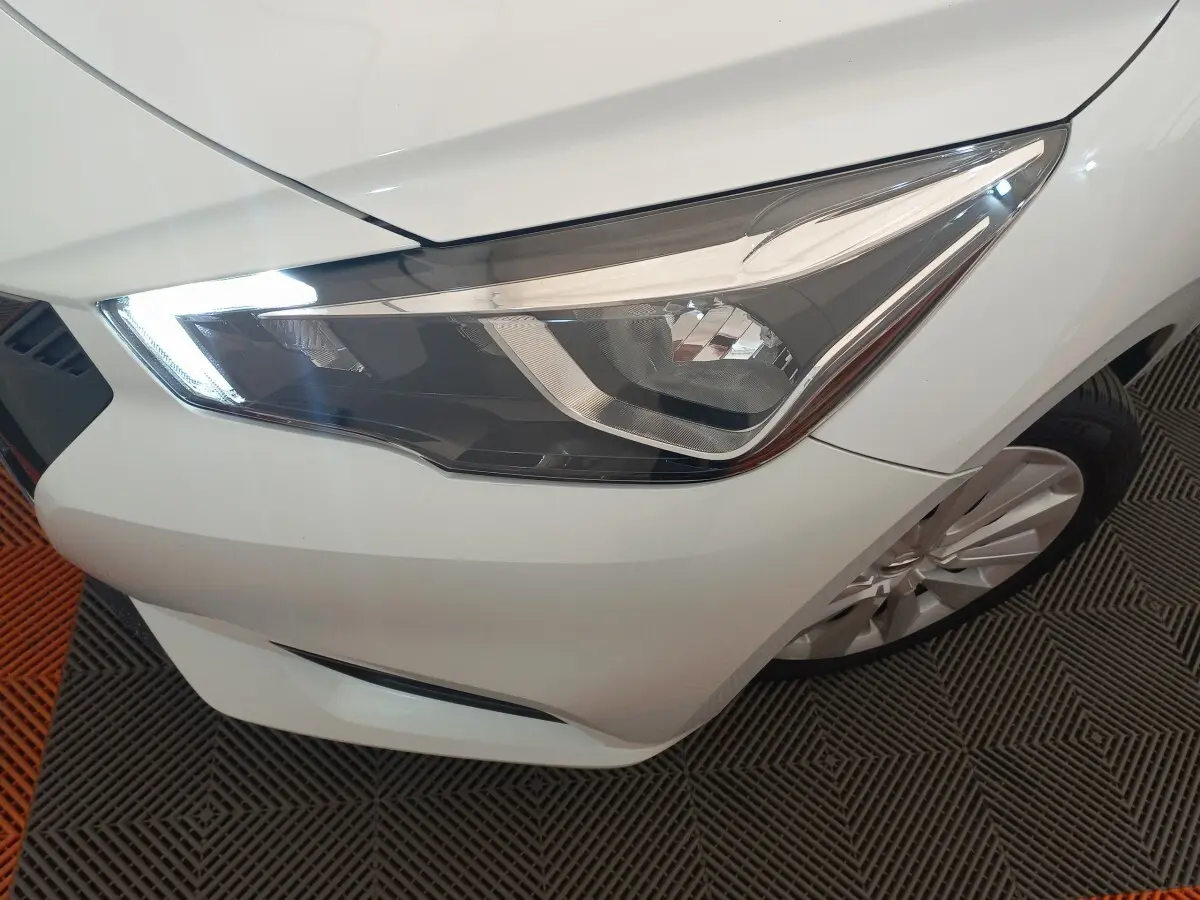 Gros plan sur le phare avant droit blanc de la Nissan Micra IG-T 90 Business Edition 2018 avec jante alliage visible.