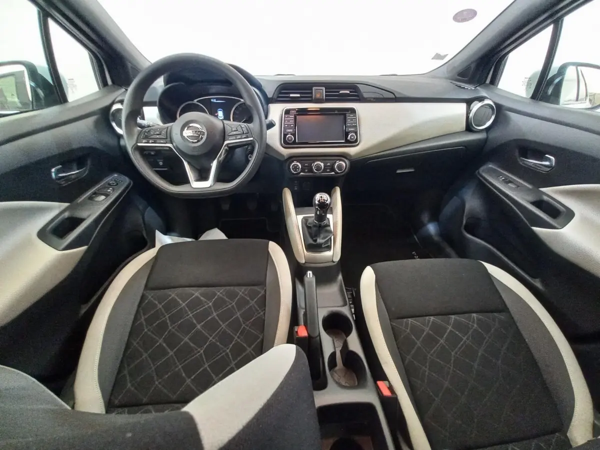 Vue intérieure avant de la Nissan Micra IG-T 90 Business Edition 2018, tableau de bord noir et beige avec volant multifonctions.