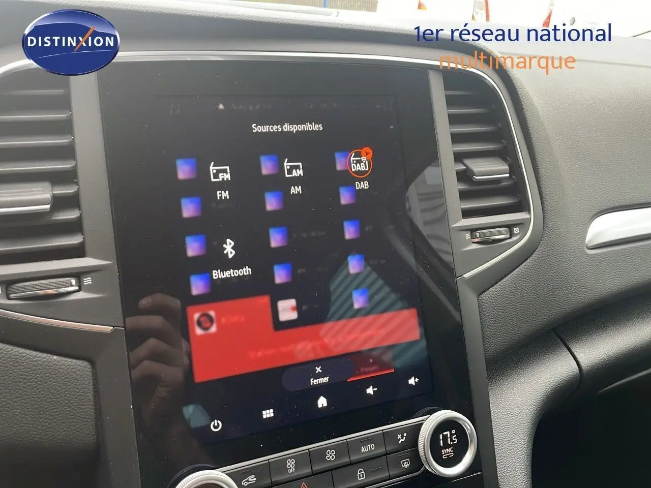 Vue rapprochée de l'écran tactile central et de la console d'une Renault Mégane Break gris Highland Metal, intérieur moderne.