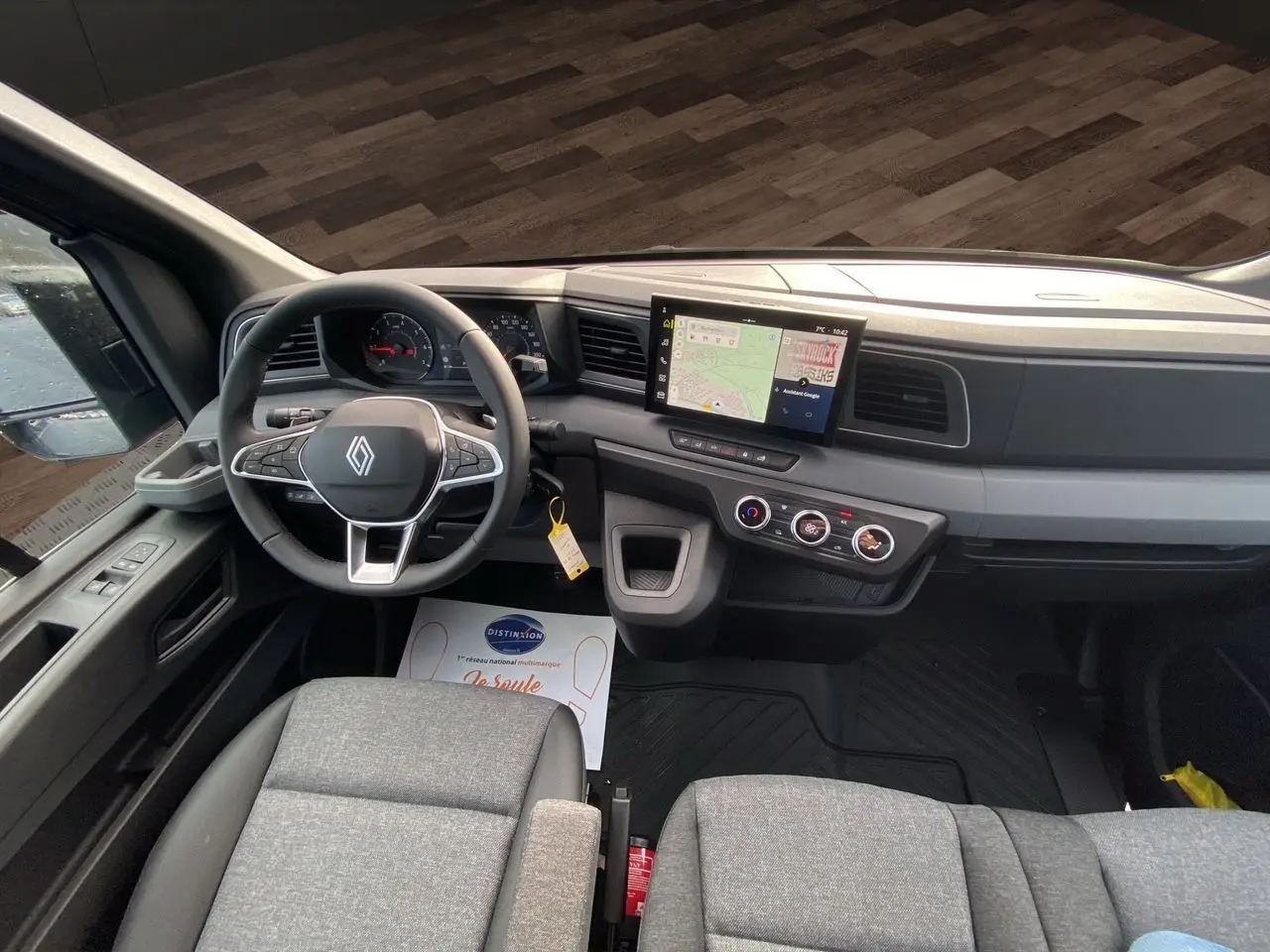 Vue intérieure du poste de conduite du Renault Master 2025, avec tableau de bord moderne et sièges gris urbain.