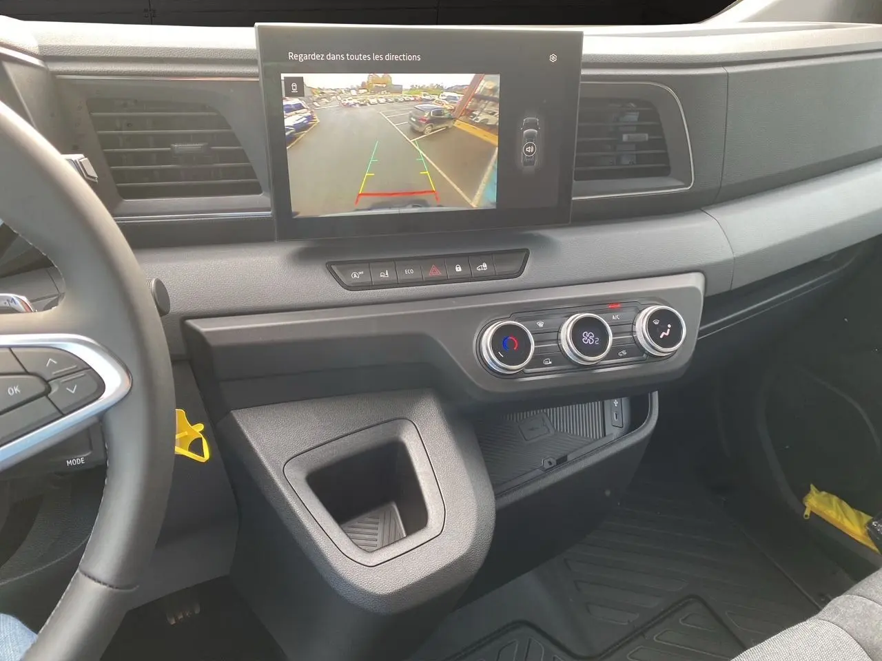 Vue intérieure du tableau de bord du Renault Master 2025 avec écran de recul et commandes de climatisation visibles.