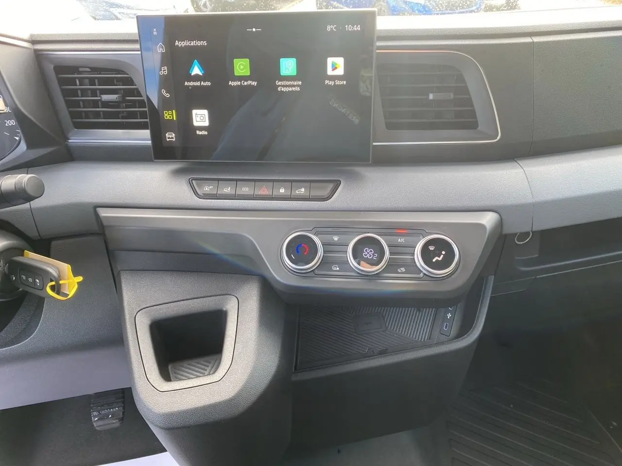 Vue intérieure du tableau de bord du Renault Master 2025 gris urbain, avec écran tactile et commandes de climatisation visibles.