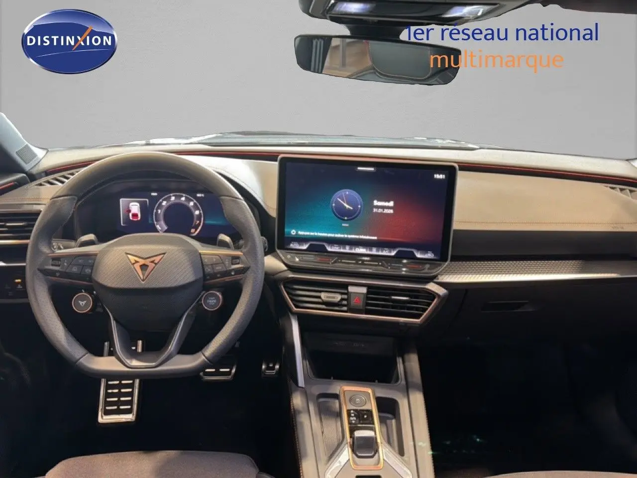 Vue intérieure frontale du tableau de bord et volant noir du CUPRA LEON ST 1.5 eTSI 2025 avec écran tactile central.