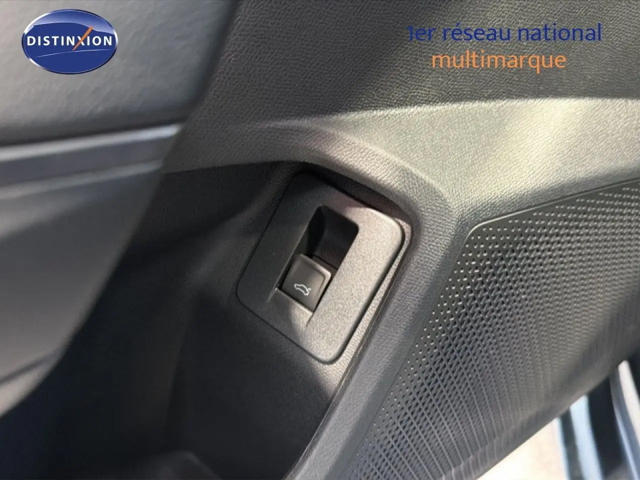 Gros plan sur le bouton d'ouverture du coffre côté conducteur dans l'habitacle d'une CUPRA LEON ST gris magnétique.