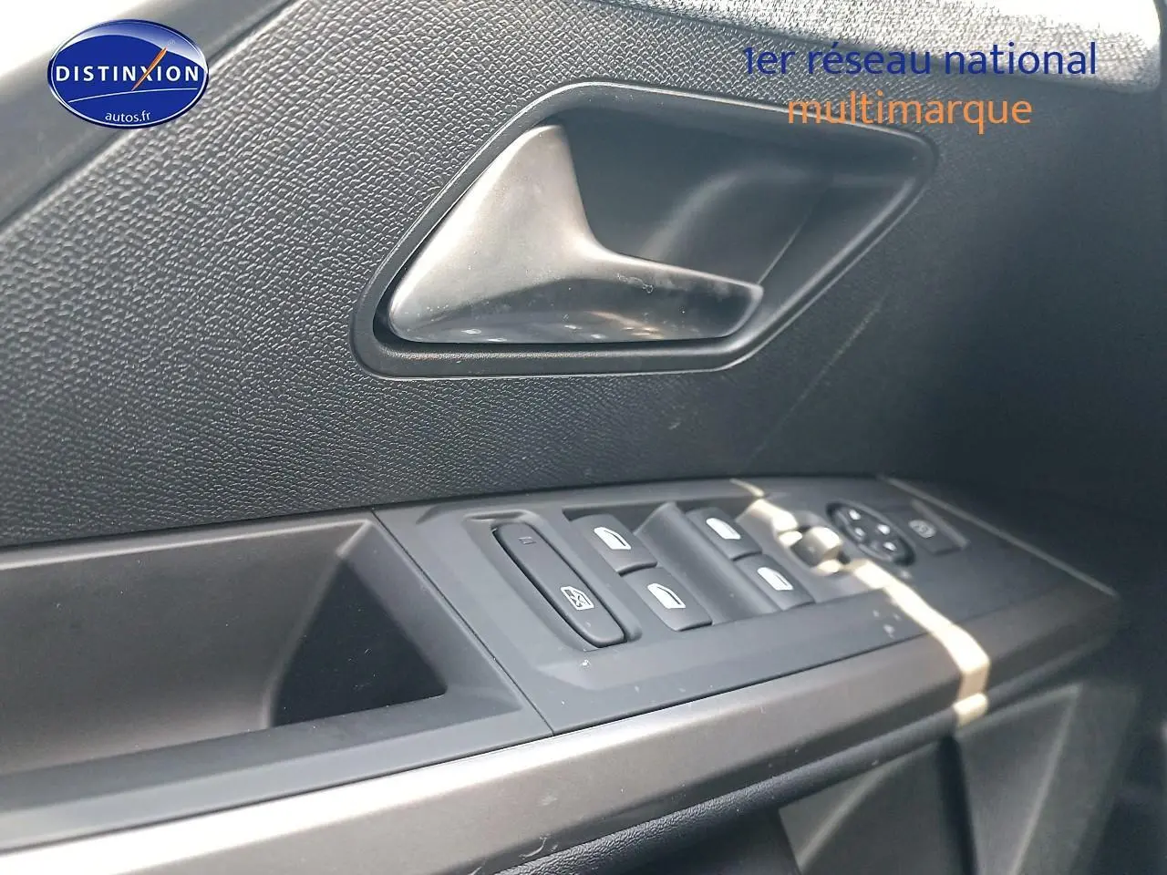 Détail de la porte côté gauche du Peugeot 3008 bleu 2025, montrant les commandes des vitres et la poignée intérieure.
