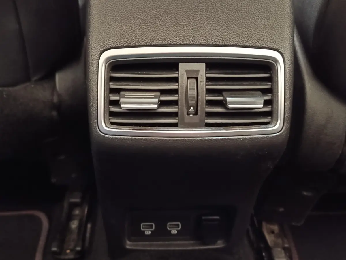 Gros plan sur la sortie d'air arrière et les ports USB du Renault Kadjar Black Edition blanc, intérieur noir.