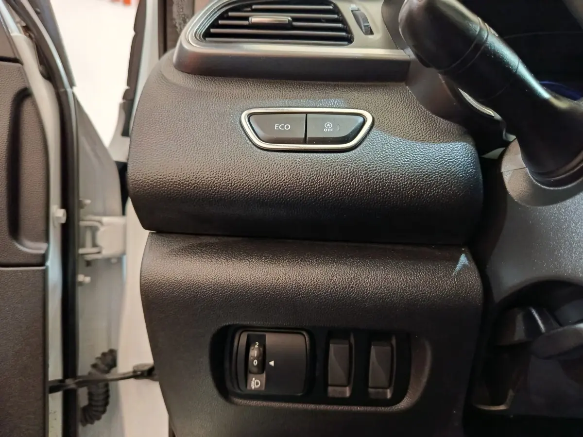 Vue intérieure côté gauche du tableau de bord noir du Renault Kadjar blanc, avec boutons Eco et réglage phares.