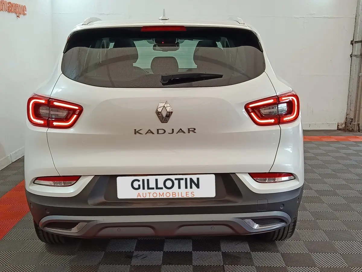 Vue arrière d'un Renault Kadjar blanc avec feux LED allumés dans un garage intérieur.