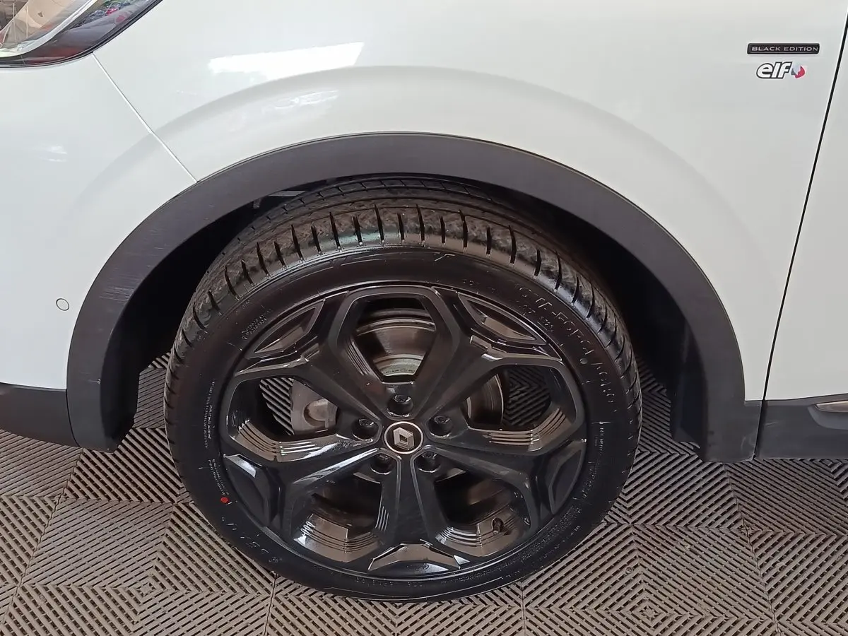 Gros plan sur la roue arrière droite noire et jante noire du Renault Kadjar blanc Black Edition.