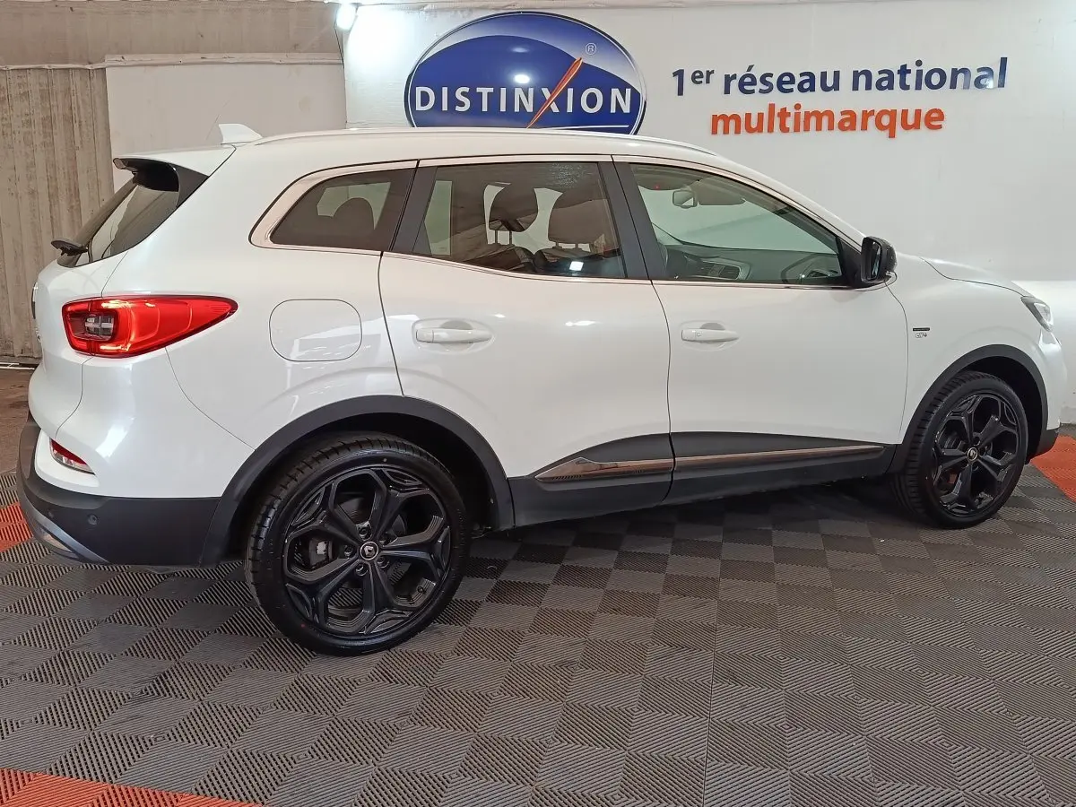 Vue de profil côté droit d’un Renault Kadjar blanc Black Edition avec jantes noires et détails chromés.
