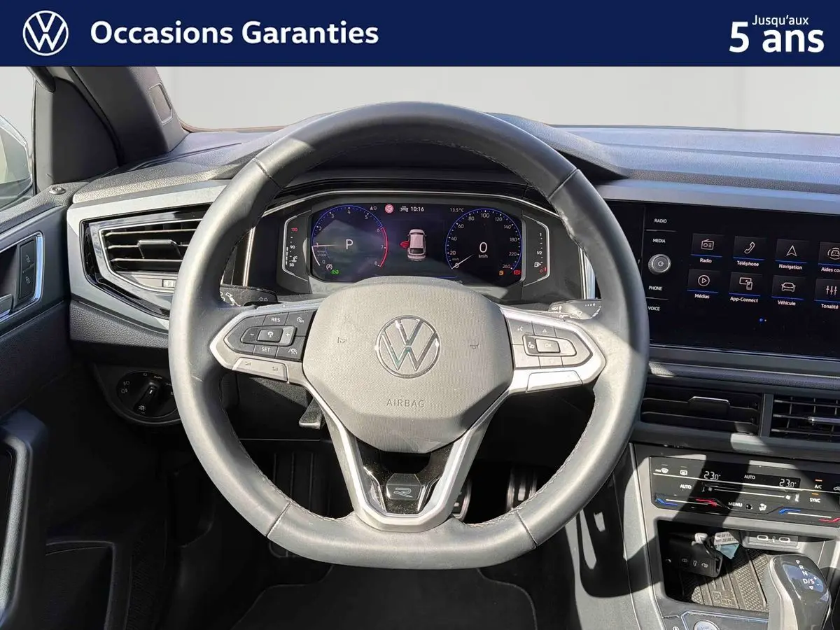 Vue intérieure centrée sur le volant cuir multifonctions et le tableau de bord digital du Volkswagen Taigo gris 2025.