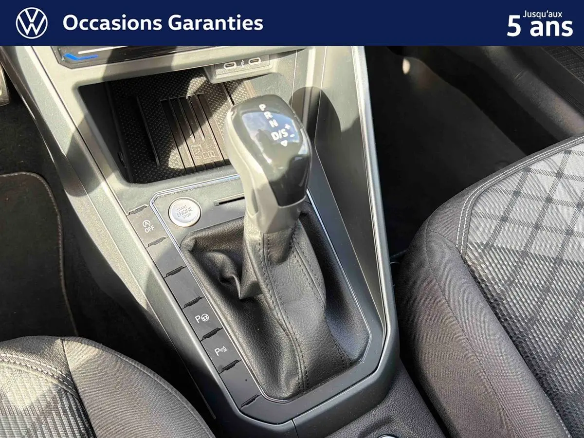 Gros plan sur la console centrale du Volkswagen Taigo gris, mettant en valeur le levier de vitesses automatique et le siège avant droit.