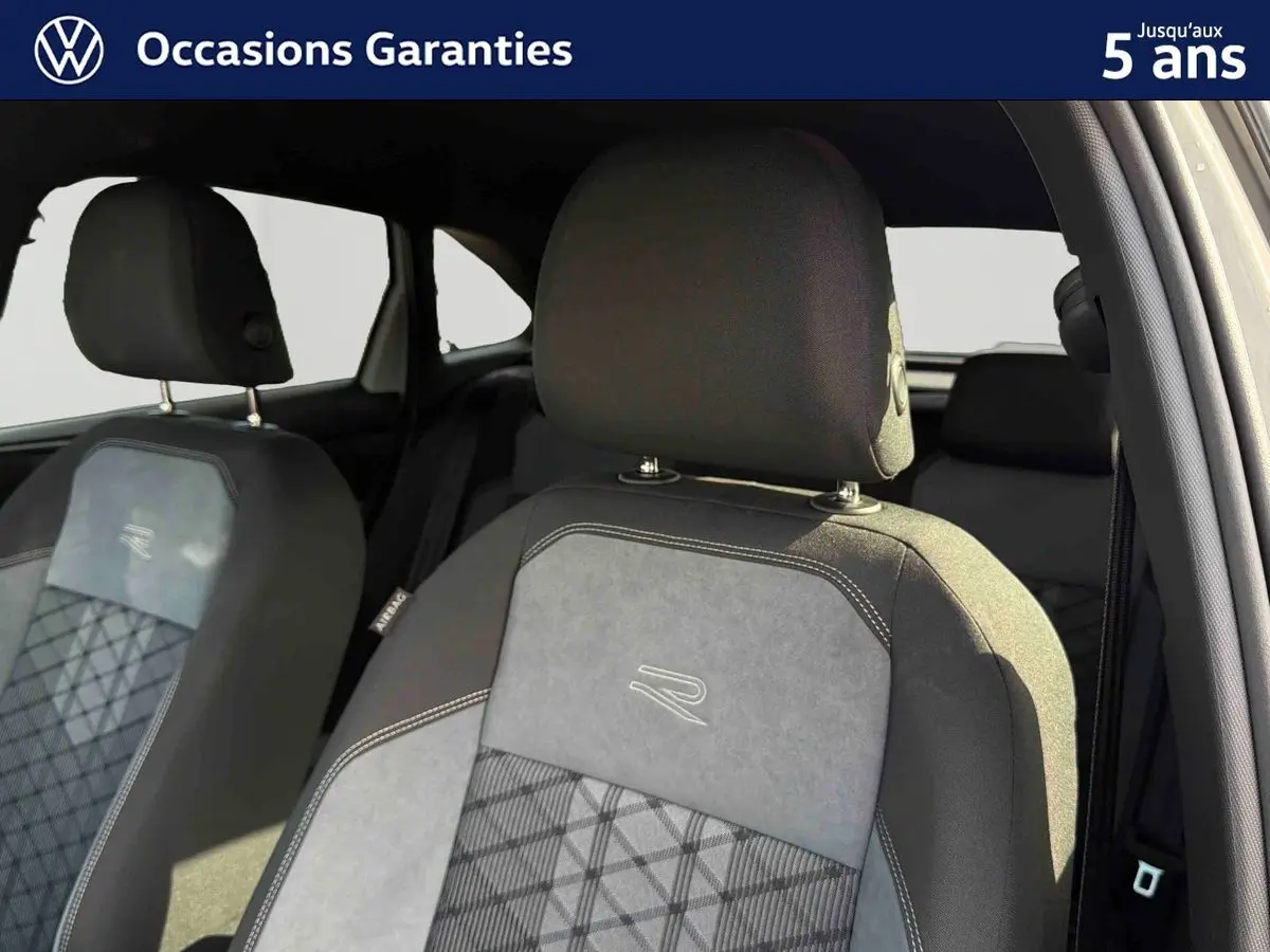 Gros plan sur les sièges avant gris du Volkswagen Taigo 2025 avec surpiqûres et logo R brodé.