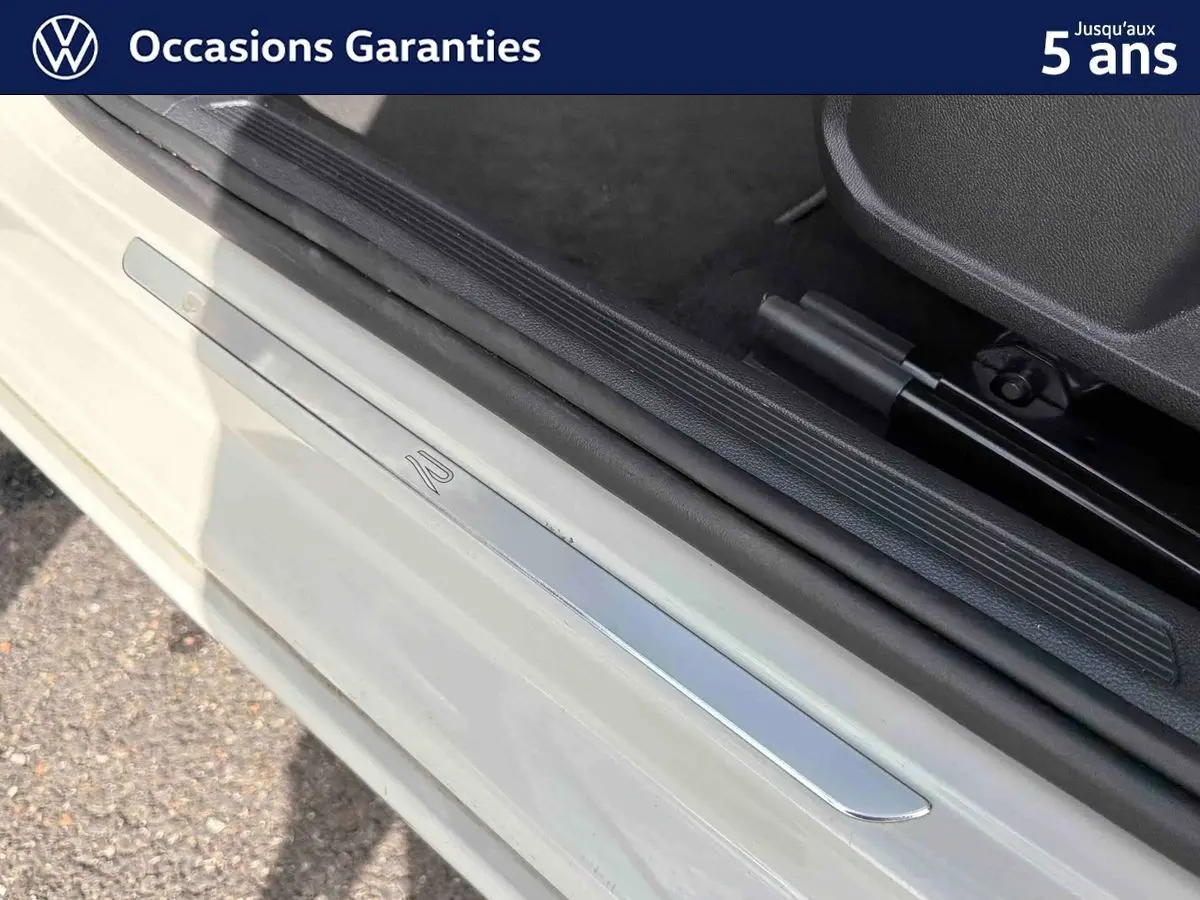 Seuil de porte côté conducteur gris clair avec insert métallique marqué du logo R sur un Volkswagen Taigo.
