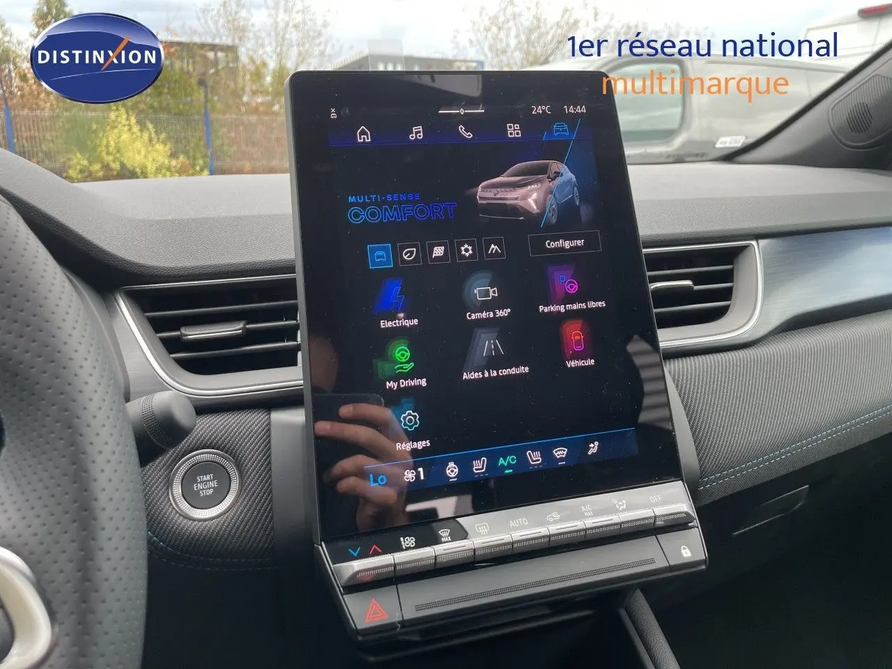 Vue intérieure centrée sur l’écran tactile vertical du tableau de bord du Renault Symbioz gris cassiopée, avec détails du volant et bouton start visible.