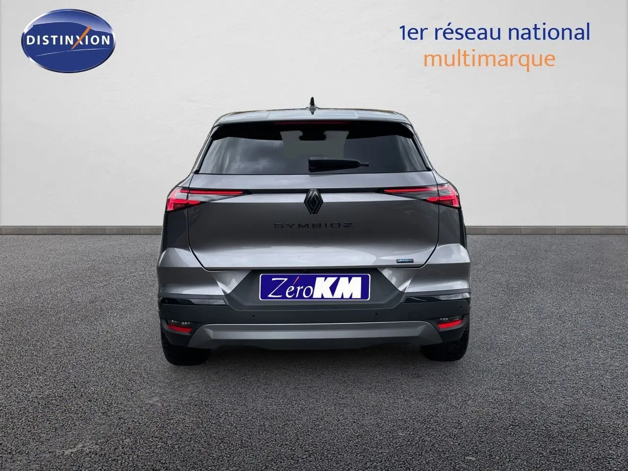 Vue arrière d'une Renault Symbioz gris cassiopée métal, avec feux arrière fins et logo central visible.