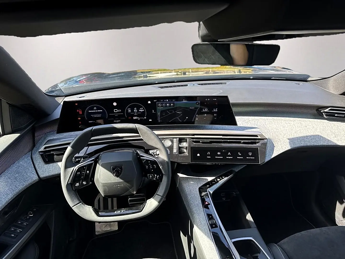 Vue intérieure avant du Peugeot 5008 Hybrid 145 GT e-dcs6 2025, tableau de bord moderne avec volant compact et écran large.