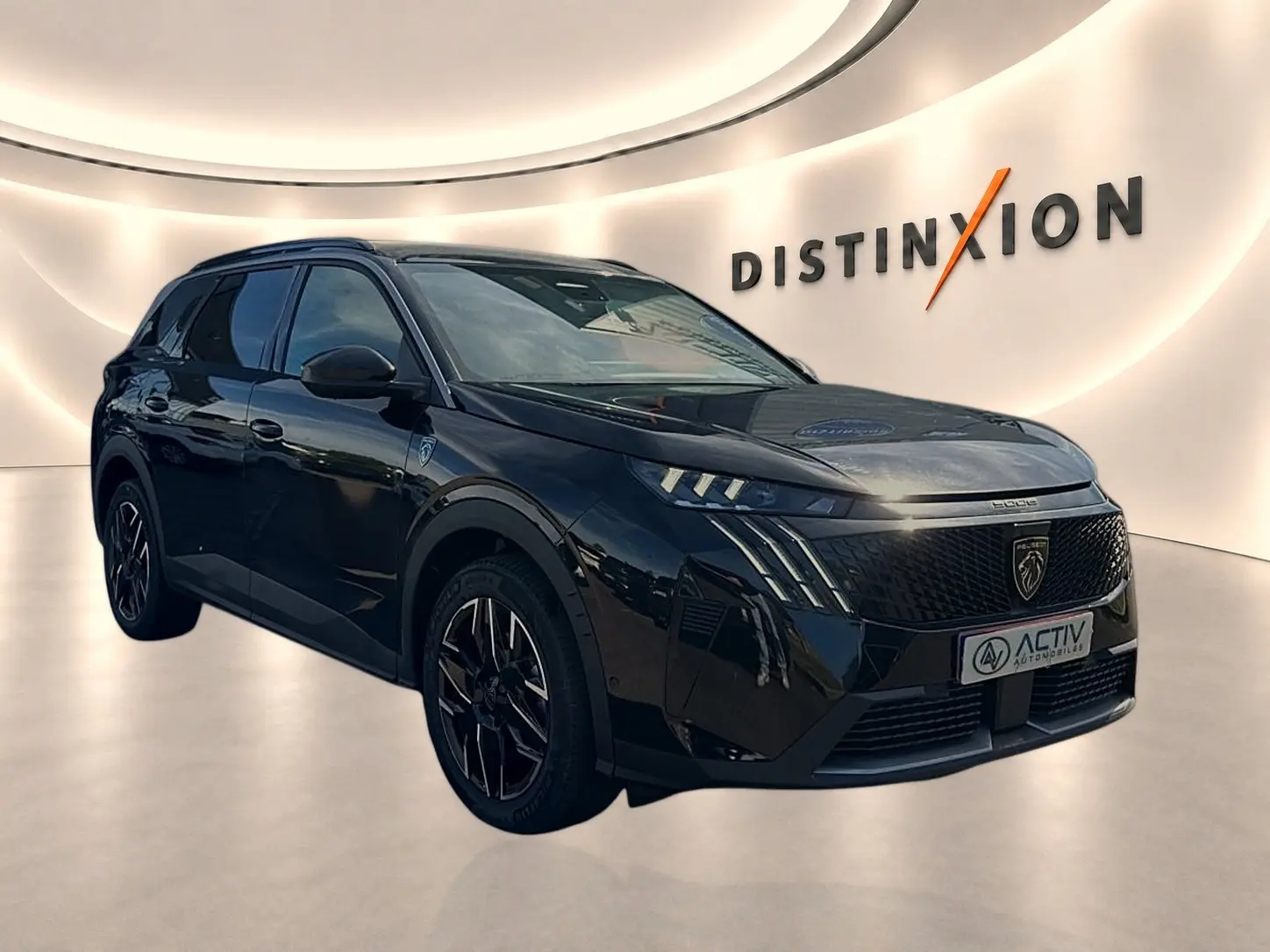 Peugeot 5008 Hybrid noir en 3/4 avant droit, avec calandre noire et jantes alliage distinctives.