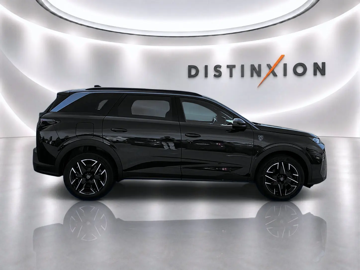 Profil droit du Peugeot 5008 Hybrid 145 GT noir brillant, avec jantes alu et logo Distinction en arrière-plan.