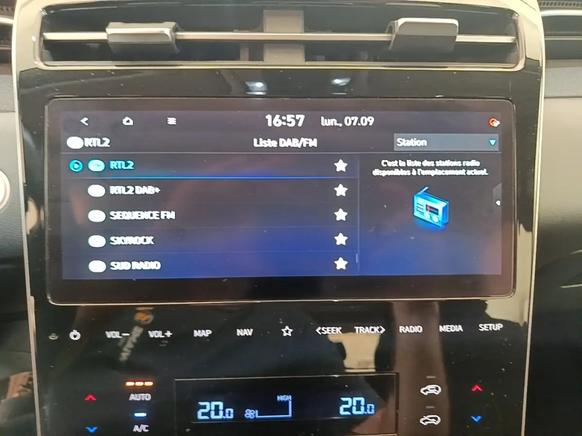 Écran tactile central du tableau de bord du Hyundai Tucson bleu, affichant la liste des stations radio.