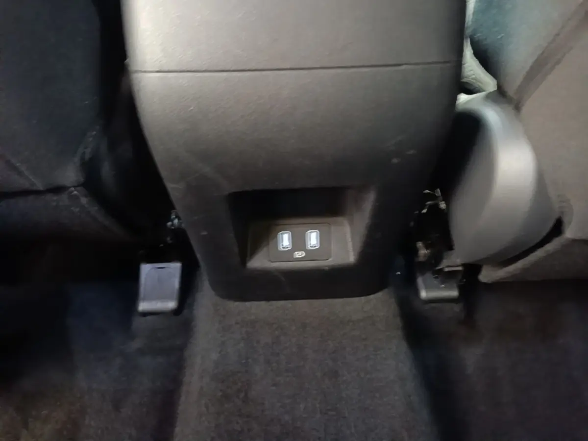 Vue rapprochée des ports USB arrière entre les sièges noirs du Hyundai Tucson bleu 2021.
