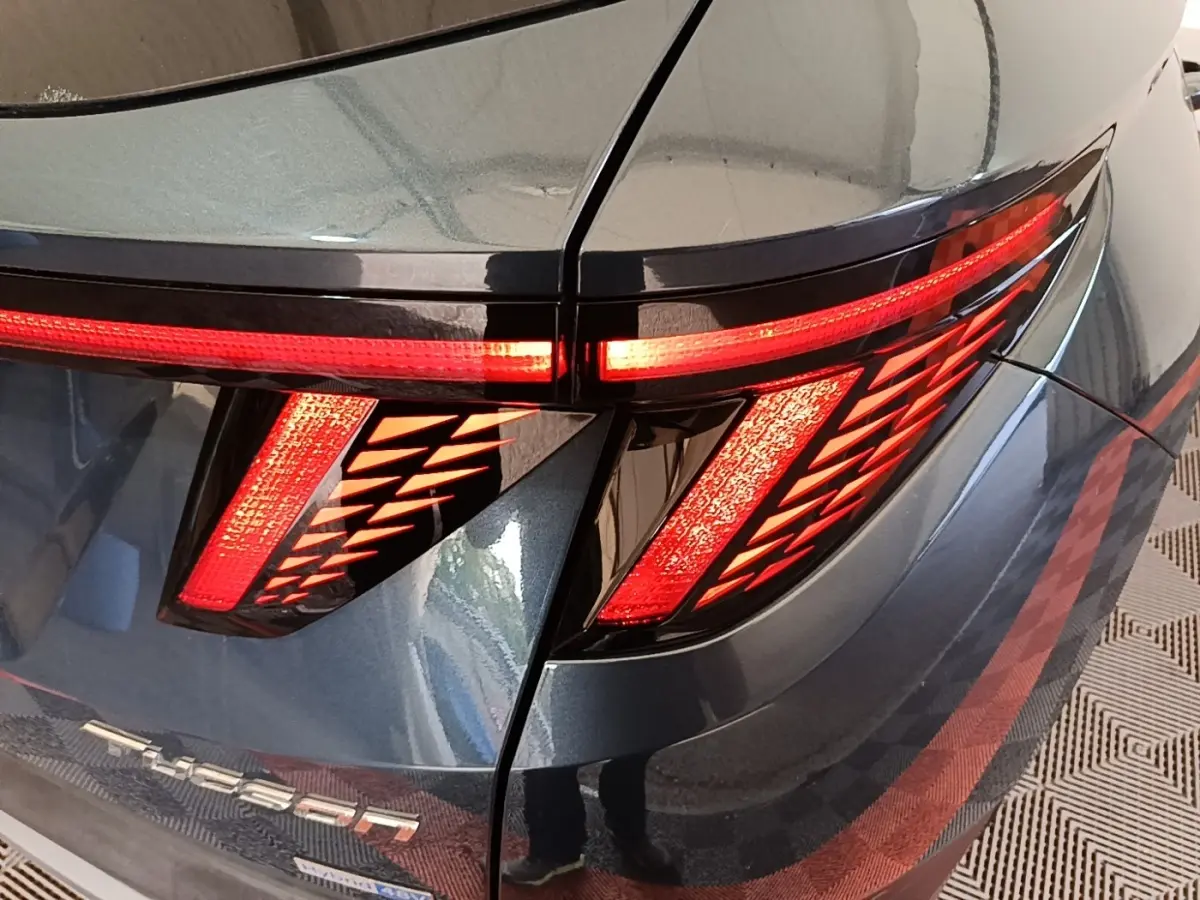 Gros plan sur le feu arrière droit rouge et la carrosserie bleue métallisée d’un Hyundai Tucson 2021.