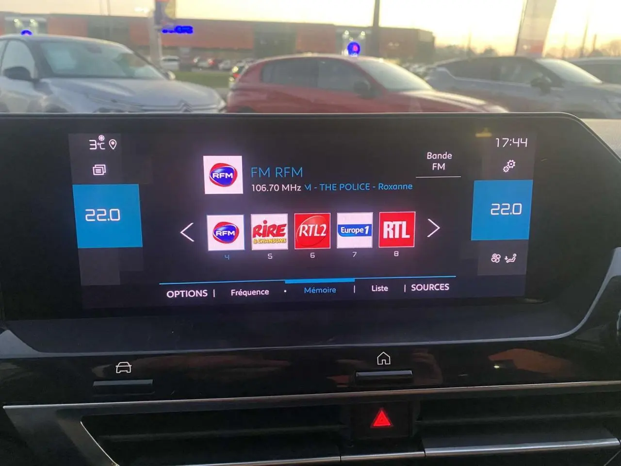 Écran tactile central de la Citroën C4 blanche de 2021 affichant la radio FM et la température à 22°C.