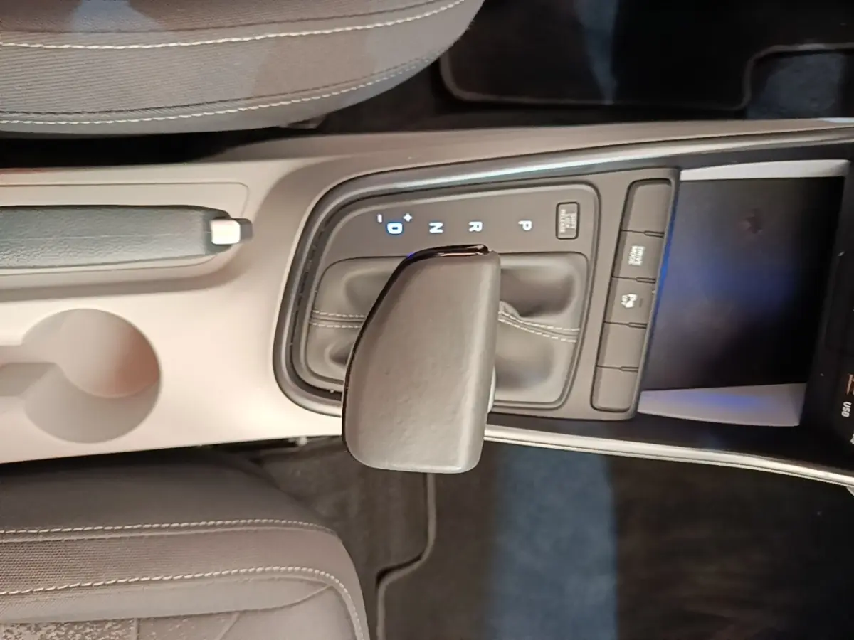 Vue rapprochée de la console centrale de la Hyundai Bayon 2024, levier de vitesse automatique en cuir gris.
