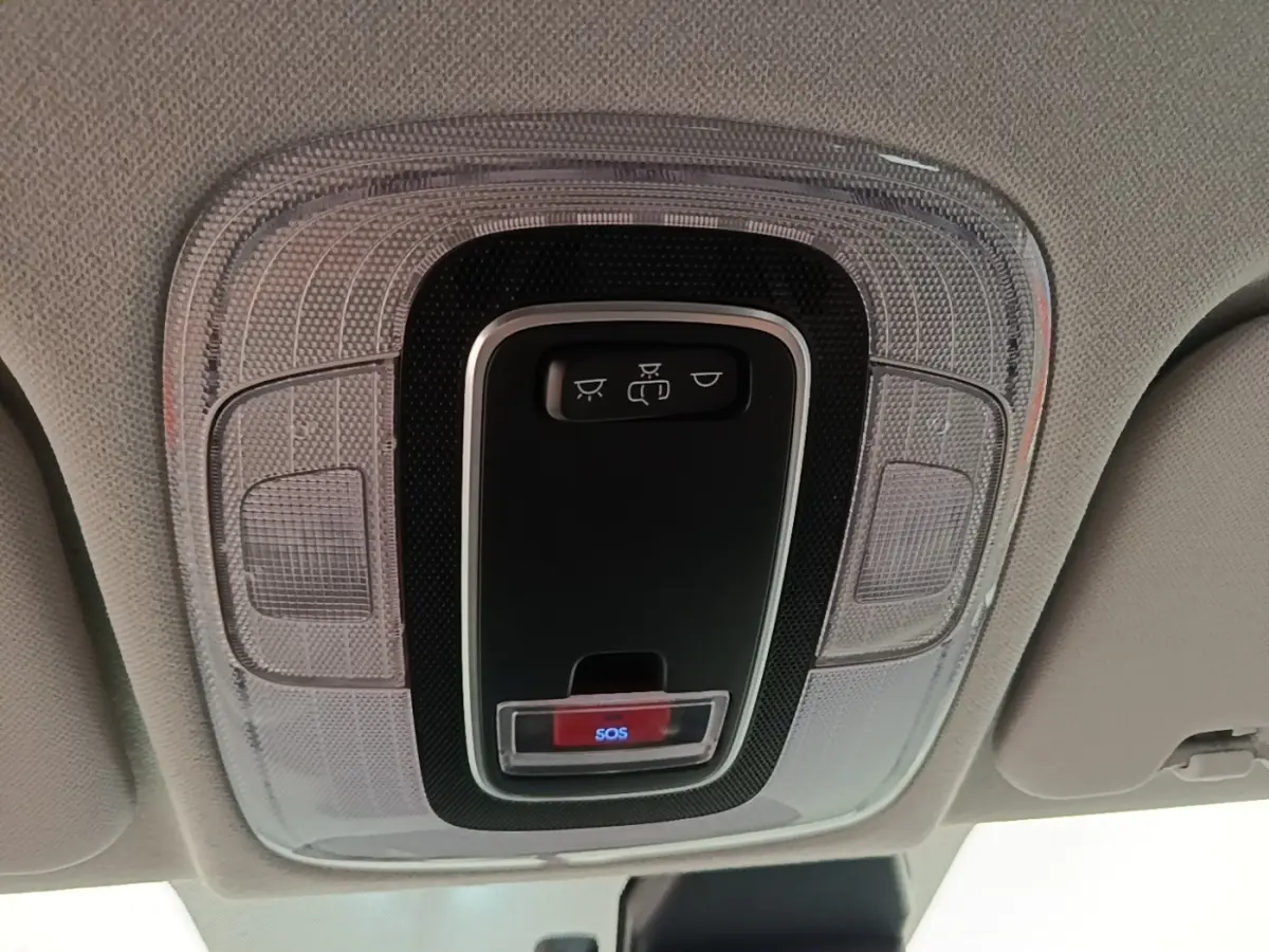 Vue en plongée sur le plafonnier intérieur avec bouton SOS et commandes d’éclairage dans un Hyundai Bayon blanc.