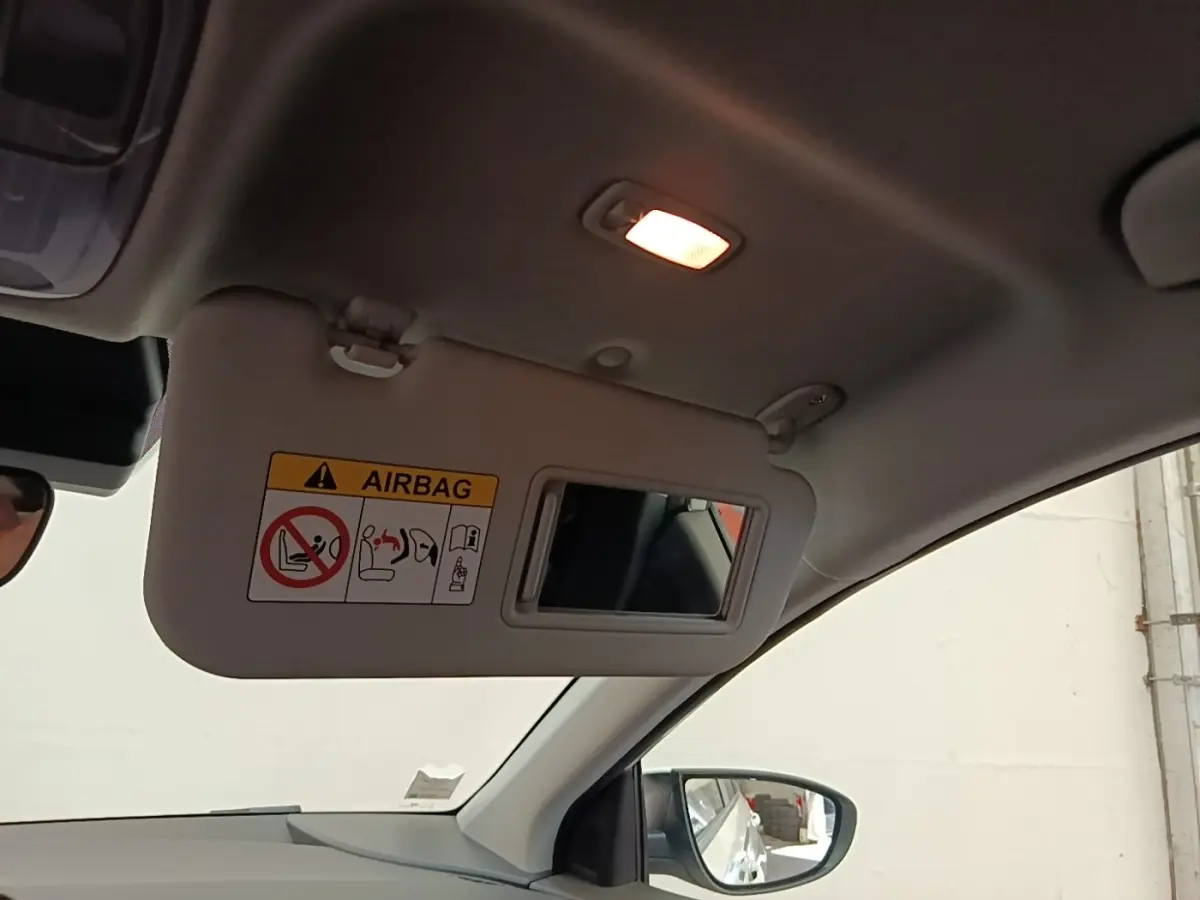 Intérieur du Hyundai Bayon 2024 blanc, vue sur le pare-soleil côté conducteur avec miroir et lumière allumée.