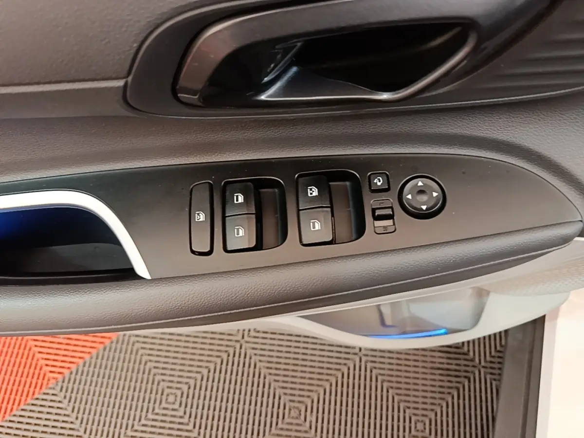 Gros plan sur la commande de lève-vitres et rétroviseurs côté conducteur intérieur d’une Hyundai Bayon blanche 2024.