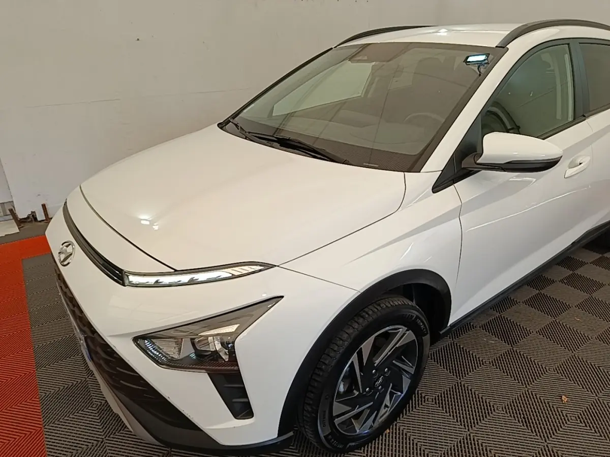 Vue 3/4 avant droit d'une Hyundai Bayon blanche 2024 avec phares LED et jantes alliage noires.