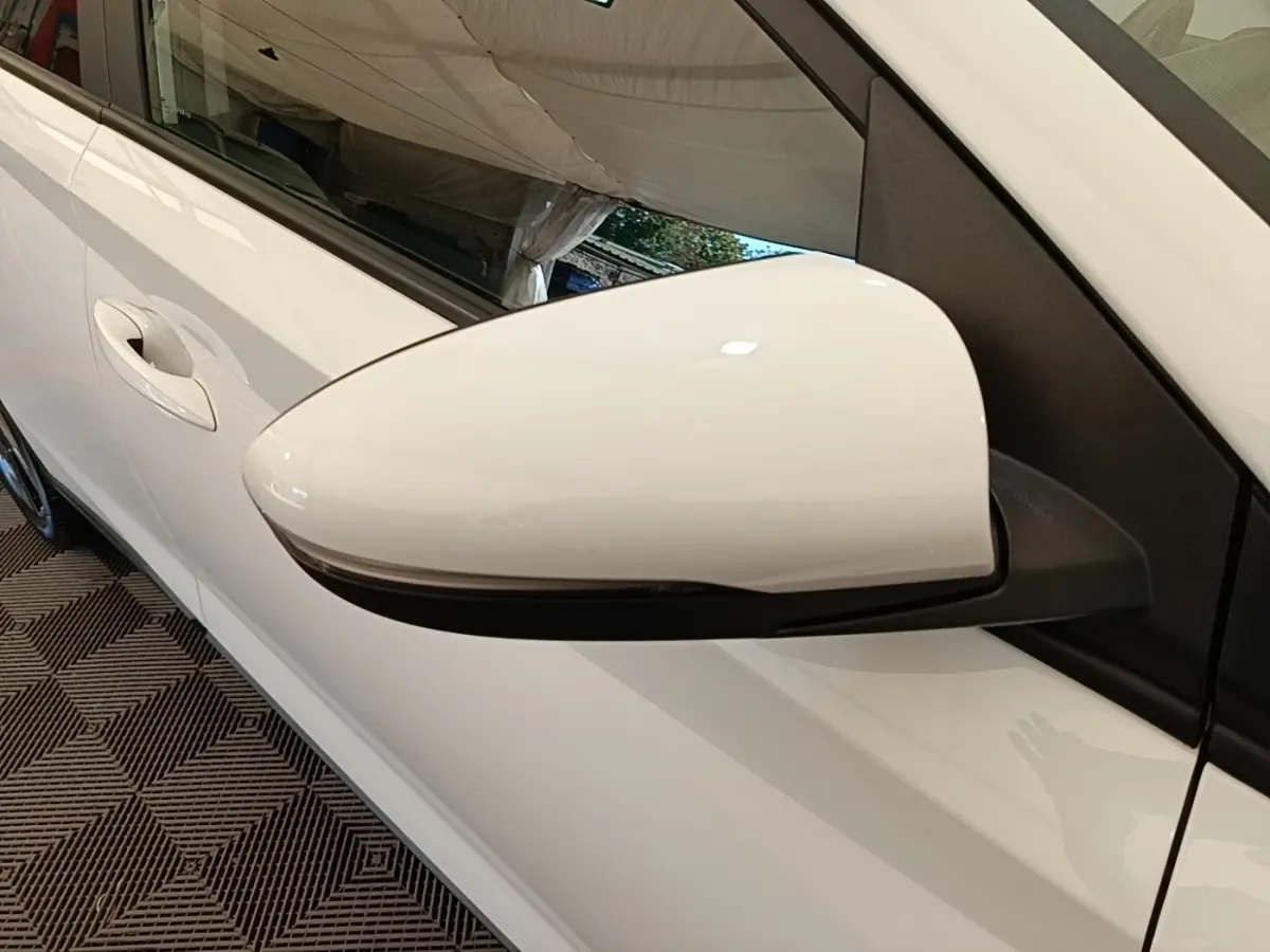 Rétroviseur blanc côté conducteur de Hyundai Bayon 2024, avec clignotant intégré et carrosserie blanche visible.