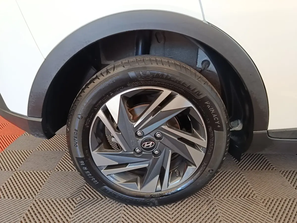 Gros plan sur la roue arrière droite d’une Hyundai Bayon blanche 2024 avec jante alliage bicolore et pneu Michelin.