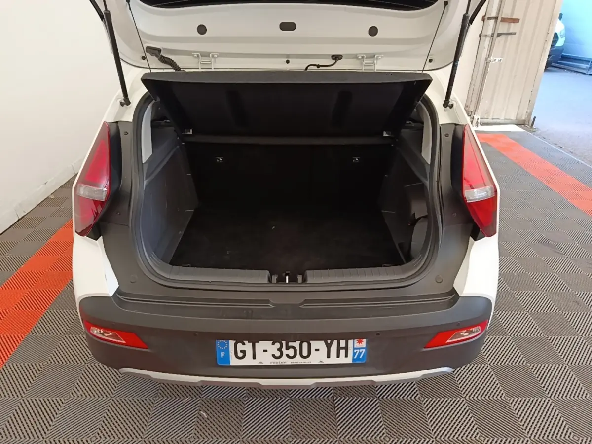 Vue arrière ouverte du coffre blanc d'une Hyundai Bayon 2024, soulignant l'espace de chargement vide et les feux arrière rouges.