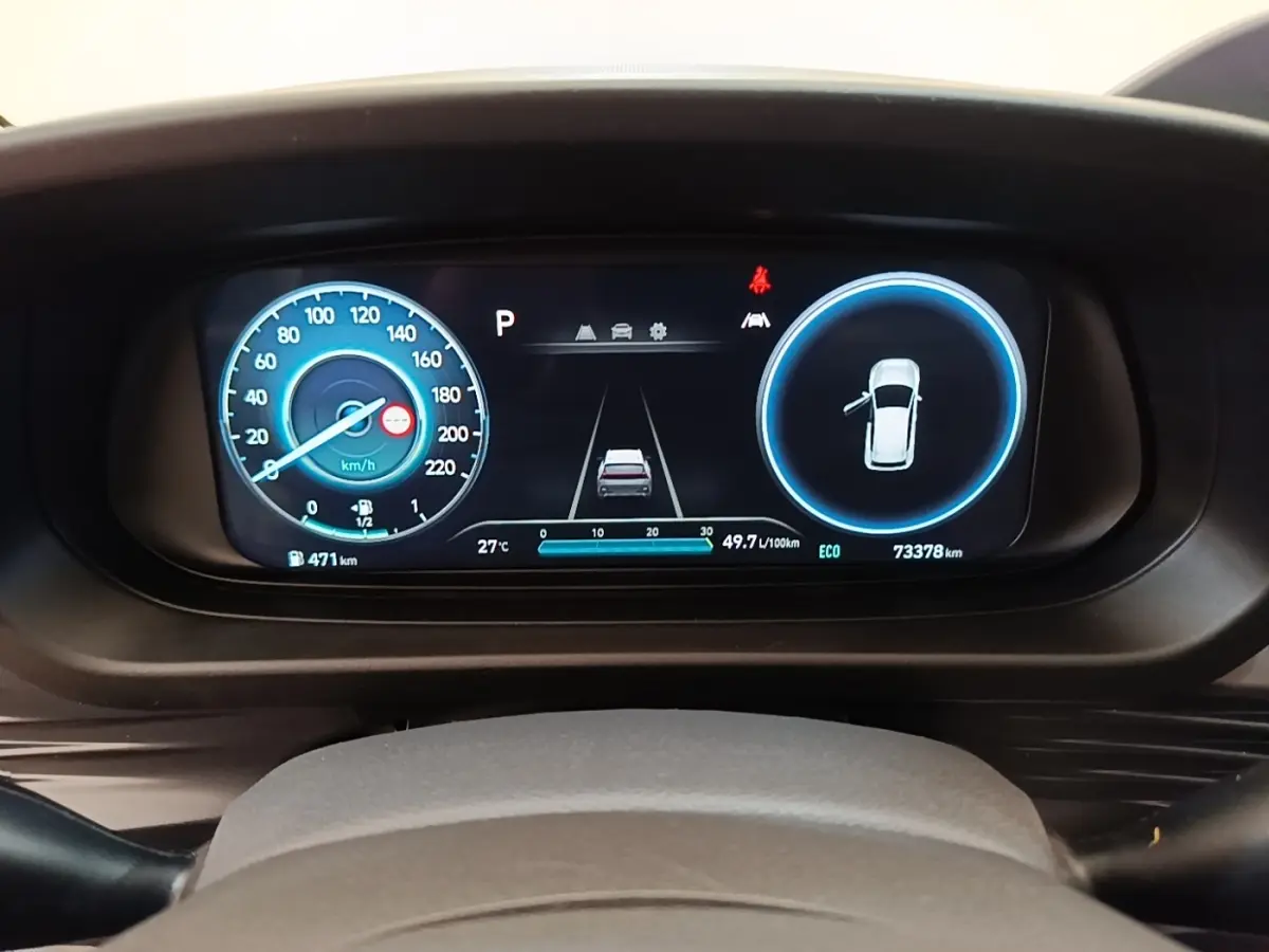 Combiné d'instruments numérique du Hyundai Bayon 2024 affichant vitesse, consommation et porte ouverte, vue frontale.