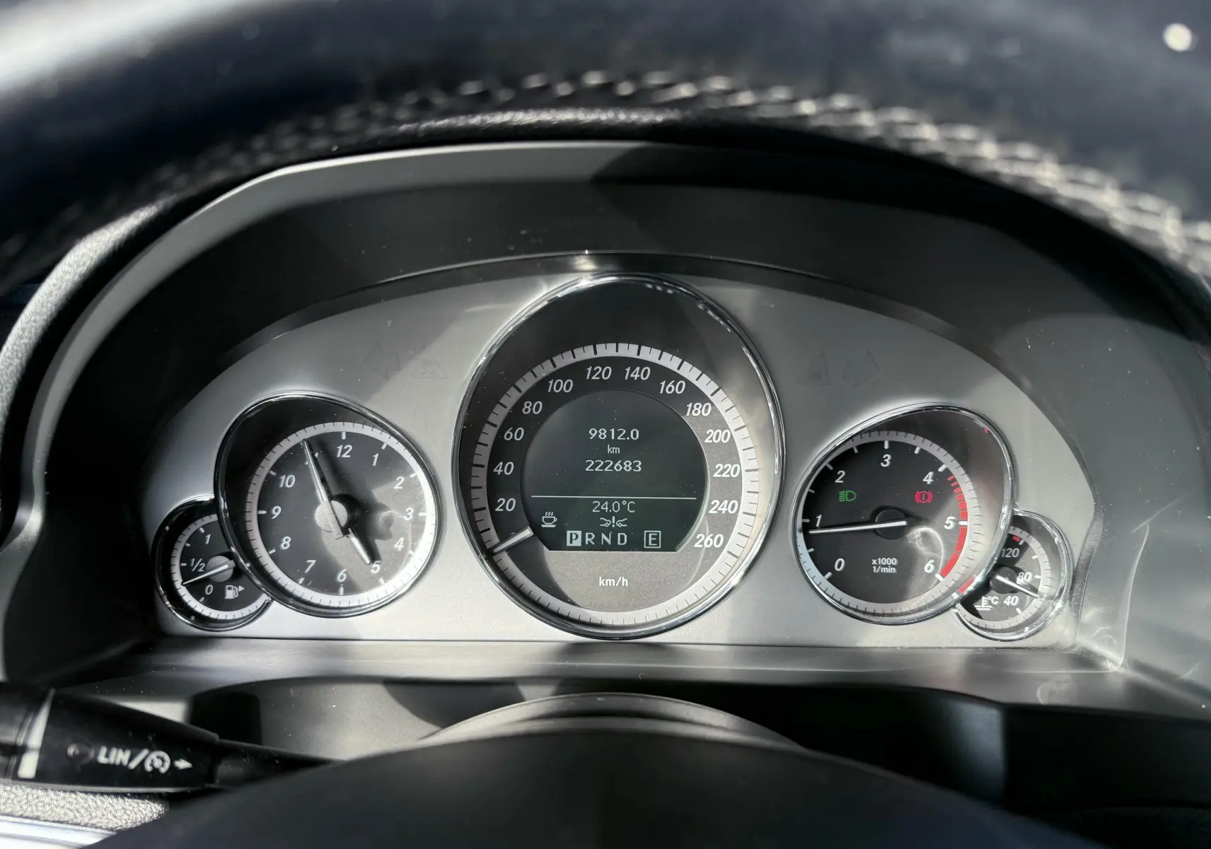 Vue rapprochée du tableau de bord de la Mercedes Classe E 250 Coupe gris, affichant les compteurs et la température extérieure.