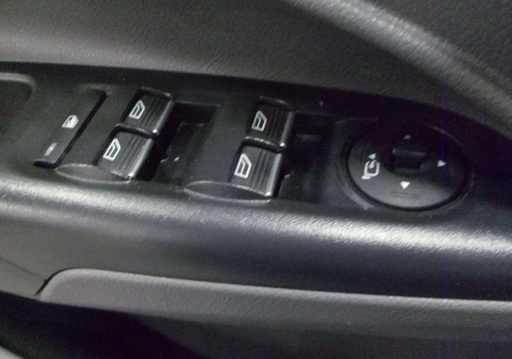 Gros plan sur les commandes des vitres et rétroviseurs électriques côté conducteur du Ford Grand Tourneo Connect 2020.