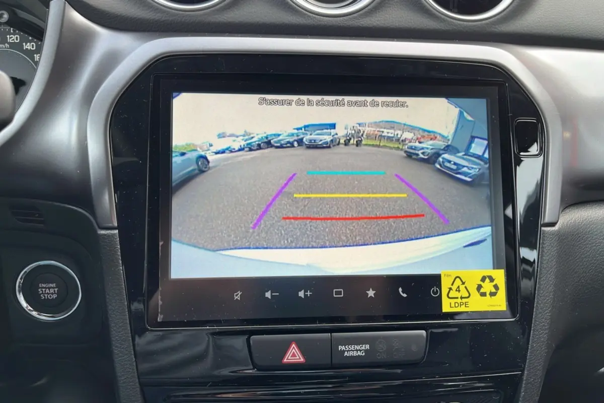Écran central du Suzuki Vitara 2025 montrant la caméra de recul avec guidage coloré et tableau de bord noir.