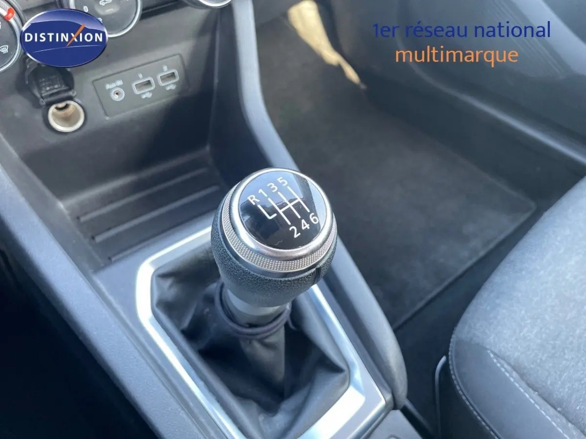 Le levier de vitesse manuel de la Renault Clio Air Nav Blue dCi 85, avec prises USB et console noire vue de dessus.