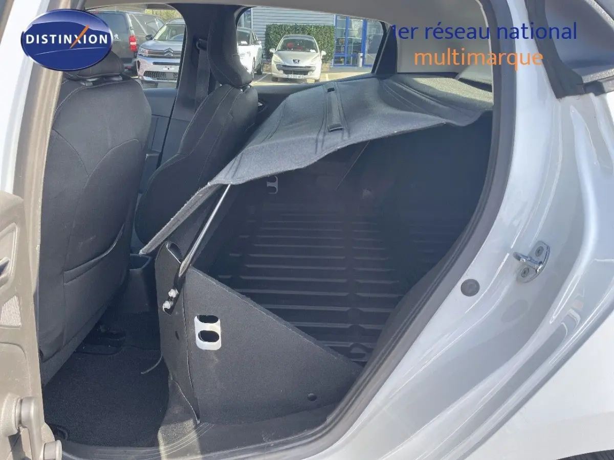 Vue intérieure côté droit d'une Renault Clio blanche 2020 avec banquette arrière rabattue et coffre visible.