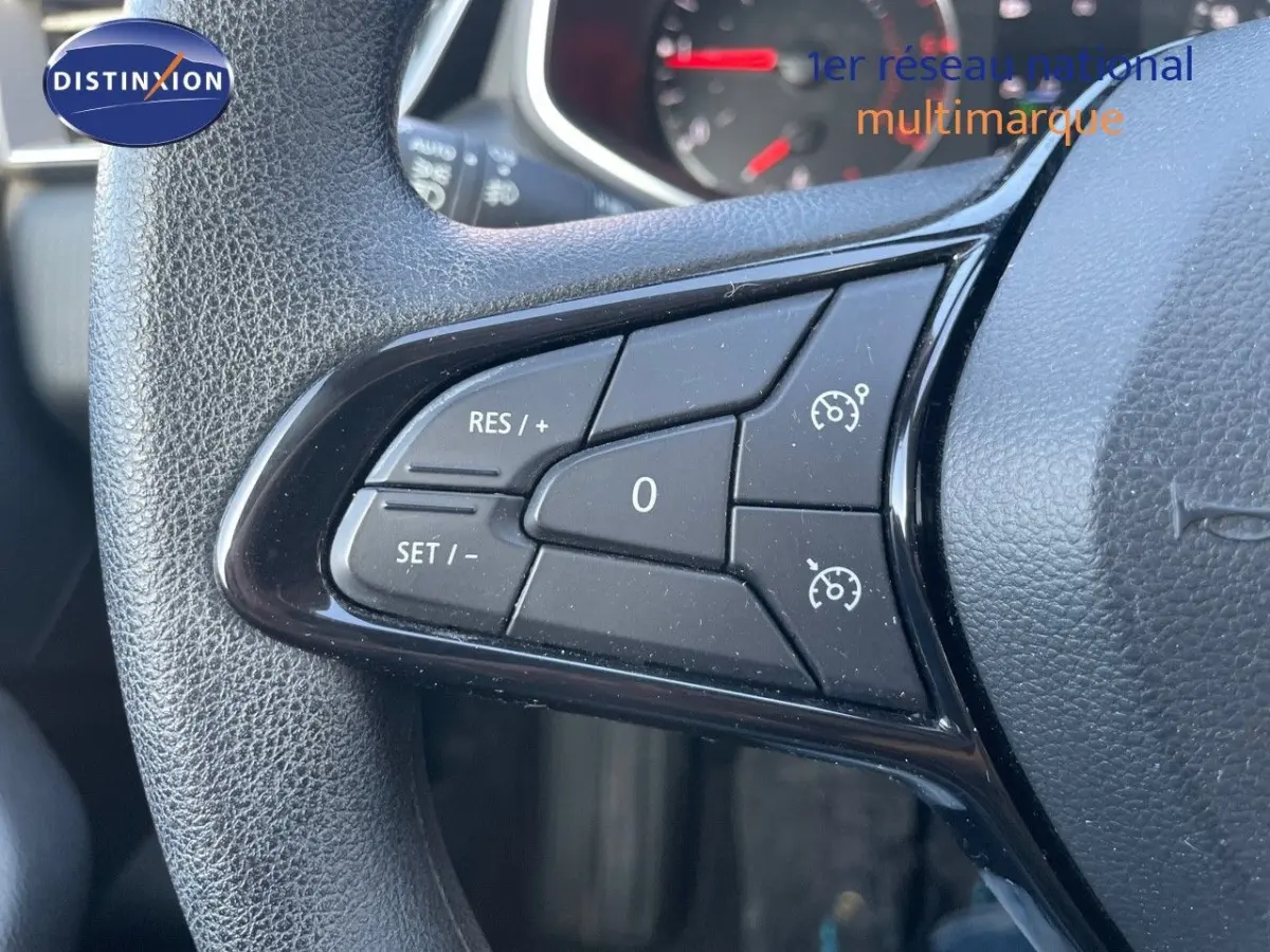 Gros plan sur les commandes de régulateur de vitesse au volant d'une Renault Clio blanche de 2020.