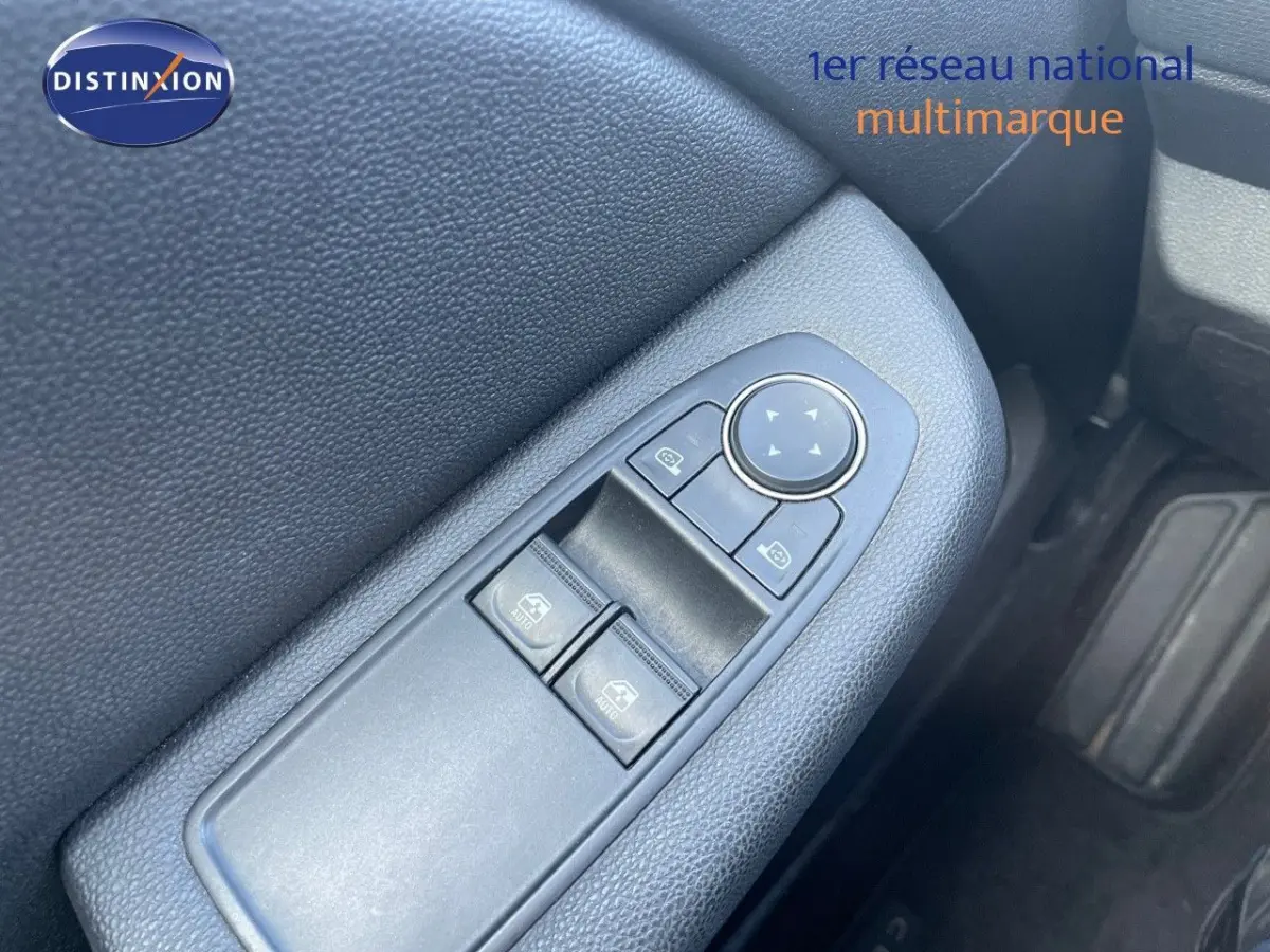 Gros plan sur la commande des vitres côté conducteur de la Renault Clio blanche, intérieur noir.