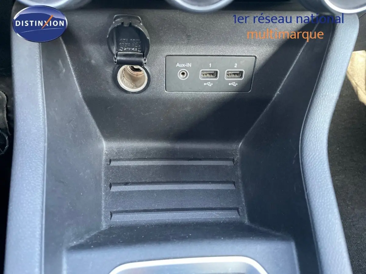 Prise 12V et ports USB visibles dans la console centrale noire d'une Renault Clio blanche version Air Nav Blue dCi 2020.